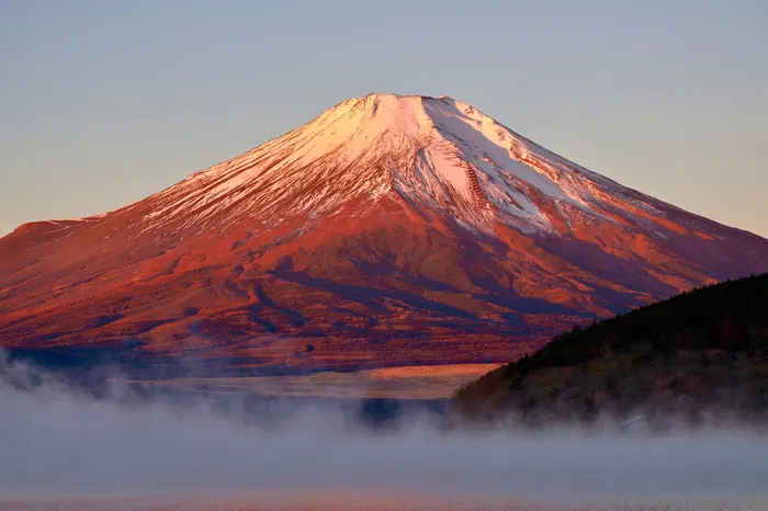 朝焼けに染まる富士山と湖面の霧